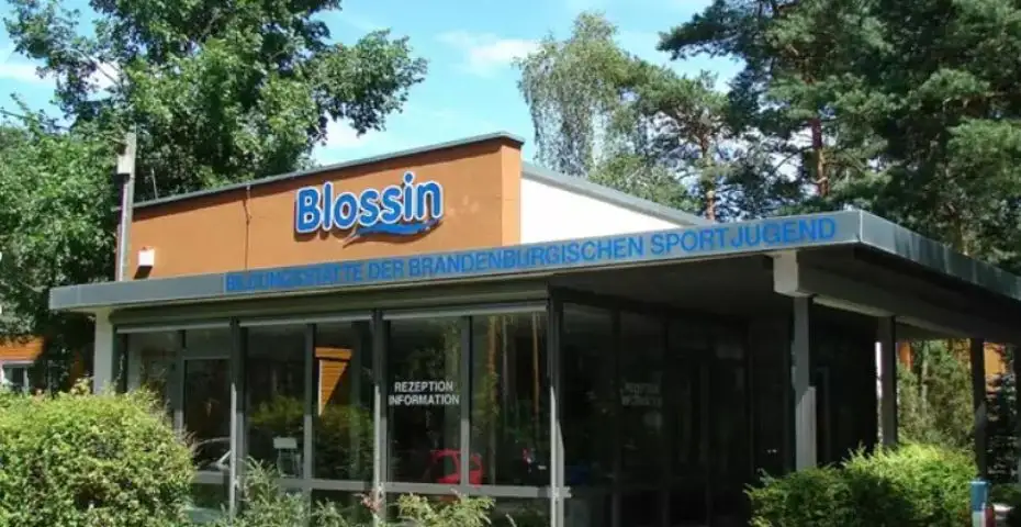 Rezeption der Jugendbildungsstätte Blossin mit Glasfassade und blauem "Blossin"-Schriftzug auf oranger Front
